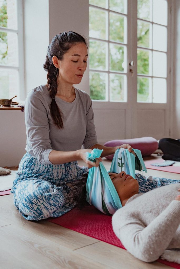 Lors d'une formation, Marisa Bai (doula) montre les gestes à effectuer pour étirer la nuque à l'aide d'un tissu japonais appelé Tenugui.