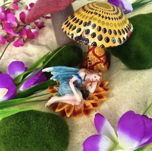 Séance d'une Thérapie par le Jeu de sable : une figurine de fée posée sur le sable