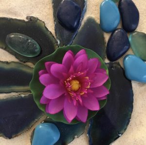Séance d'une Thérapie par le Jeu de sable : une fleur de lotus et des cailloux posés sur le sable