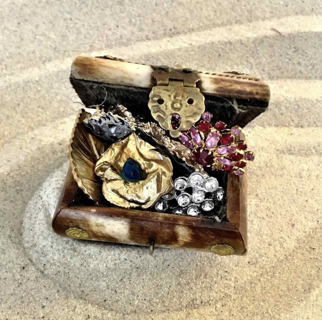 Séance d'une Thérapie par le Jeu de sable : un coffret rempli de trésor, posé sur le sable