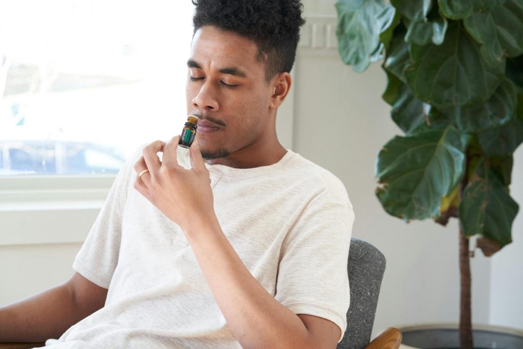 Un homme respirant une huile essentielle pour se relaxer