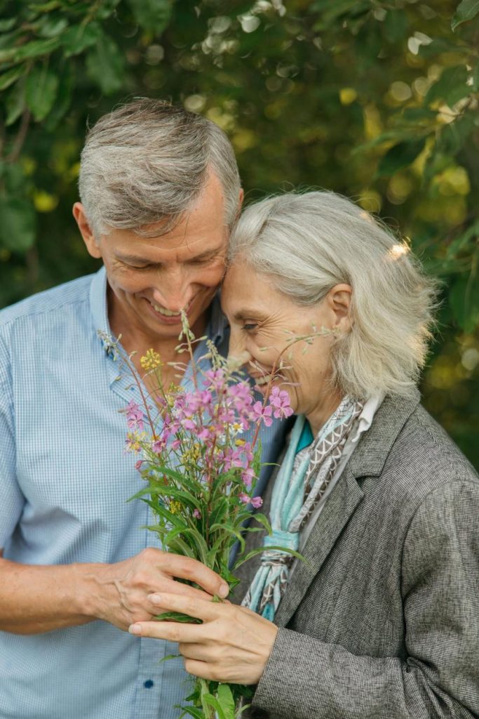 Couple âgés respirant un bouquet de fleurs