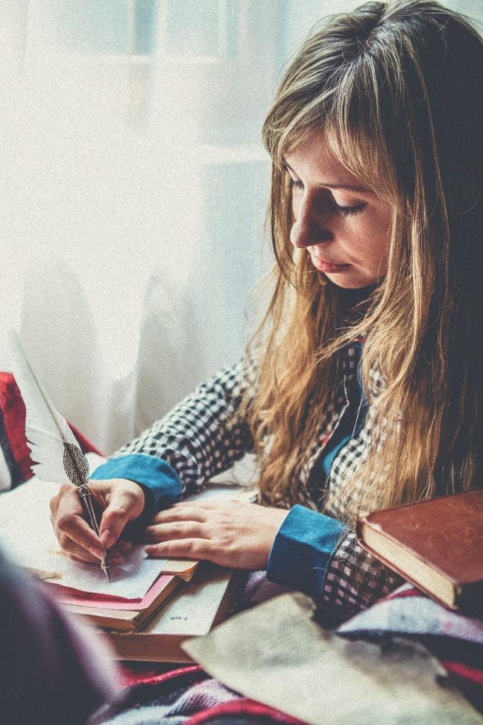 une personne  écrit sur une carnet les meilleurs moments de sa journée